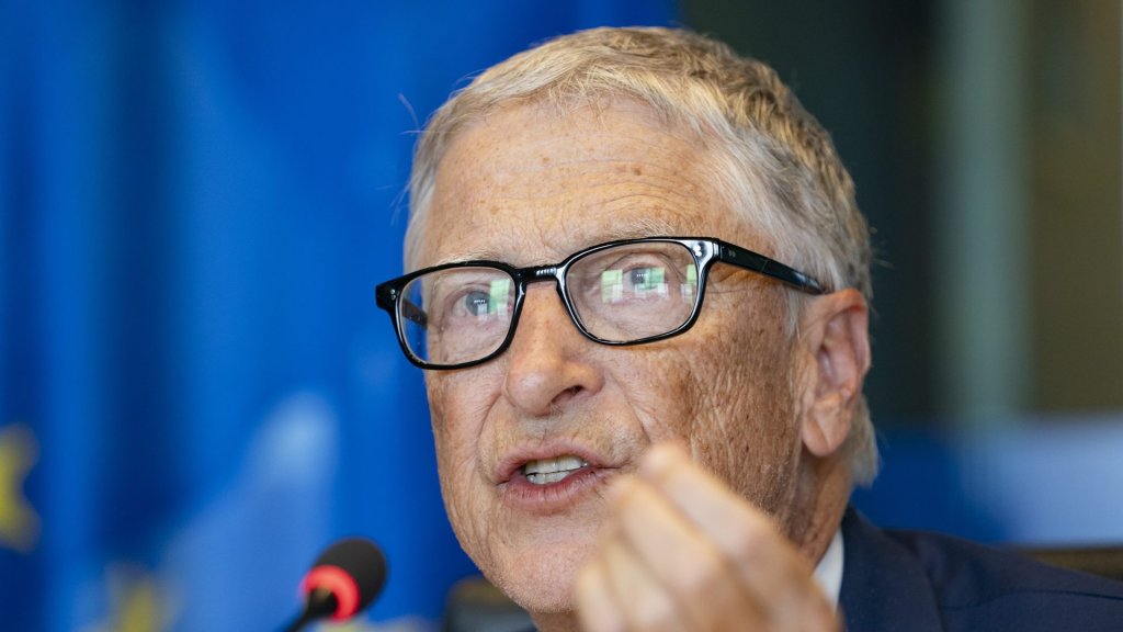 bill gates ai warning: Bill Gates speaking at the European Parliament in June 2025, hand raised mid-sentence