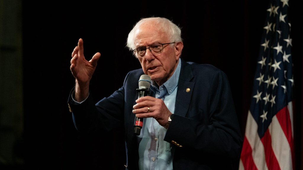 bernie sanders ai legislation: Senator Bernie Sanders speaking with a raised hand beside a US flag