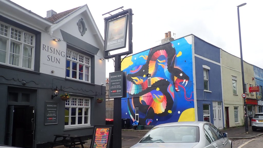 Bristol AI mural row: a hand painted Upfest mural beside the Rising Sun pub in Bristol