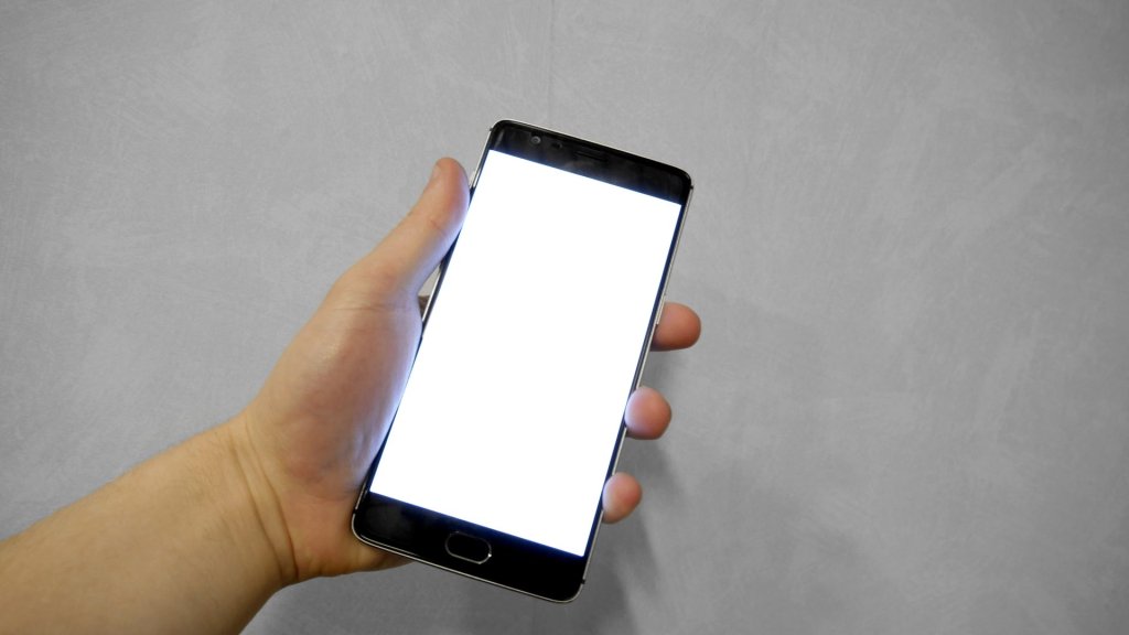 Instinct AI assistant concept: a hand holding a smartphone with a blank white screen