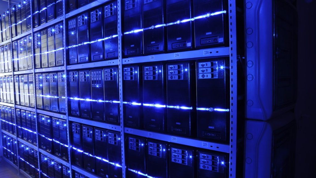 Jev AI model concept: a dark server hall lit blue, rows of machines answering each other without a human in the room
