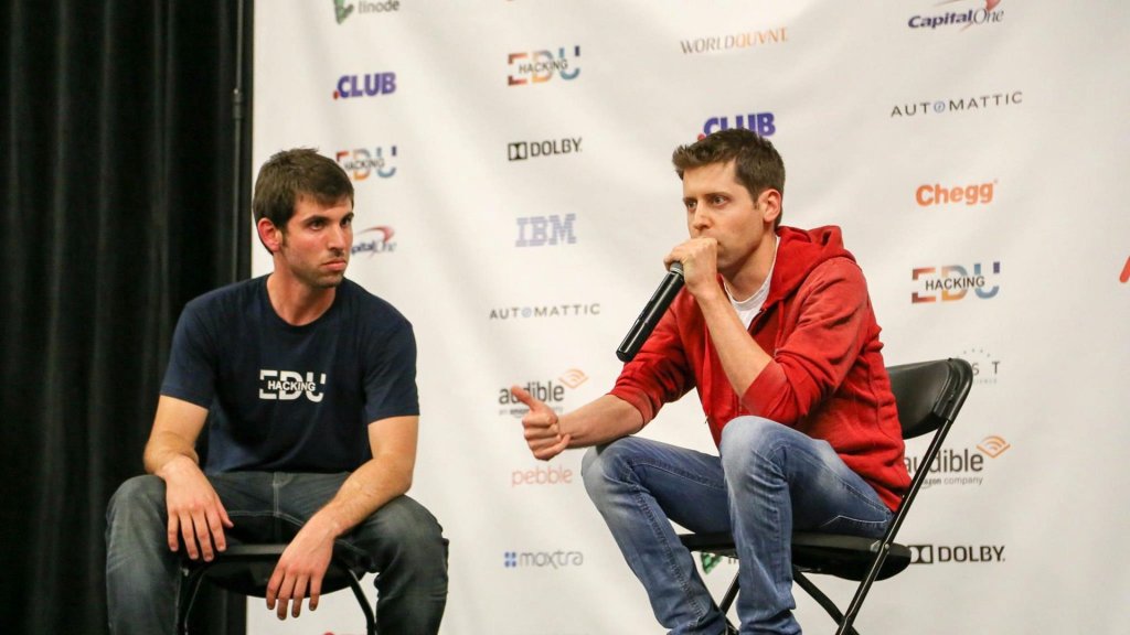 open ai dev day: Sam Altman speaking on stage with a microphone at a fireside chat