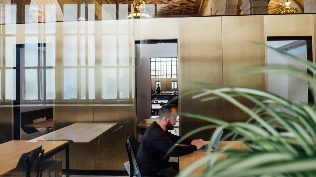 AI impact on middle managers: a lone employee works on a laptop in a quiet open office