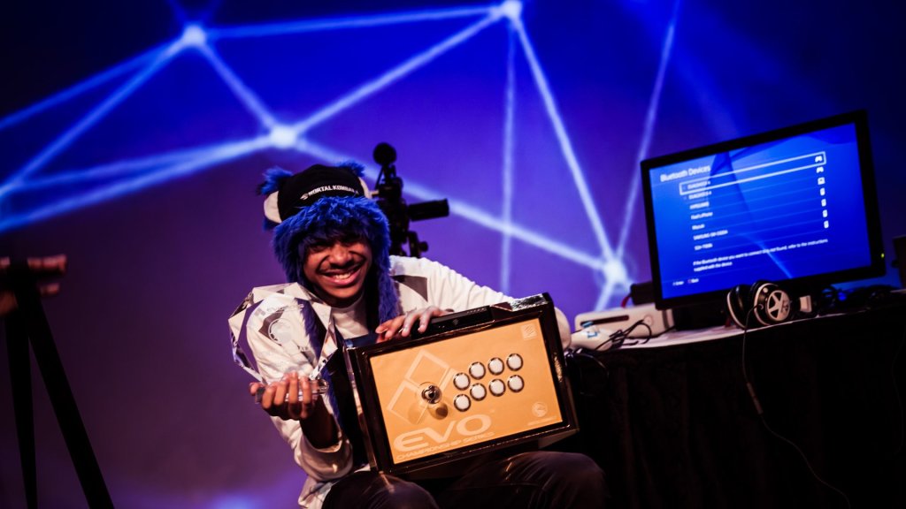 SonicFox Nexcon AI poster story: SonicFox smiling with an EVO arcade stick and trophy at Evo 2015