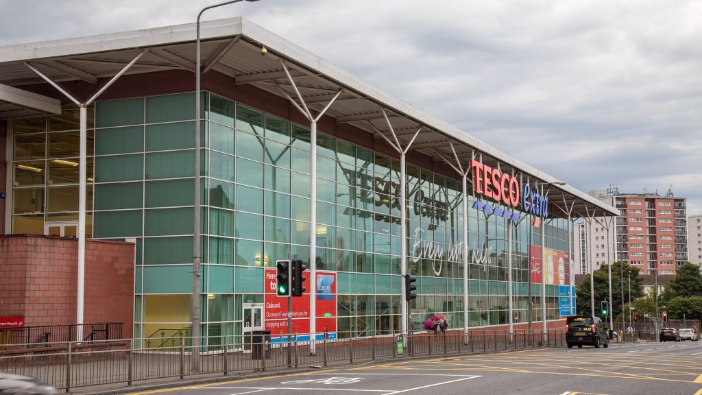 Tesco Clubcard AI feature rollout: a Tesco Extra store in Glasgow with Clubcard signs in the window