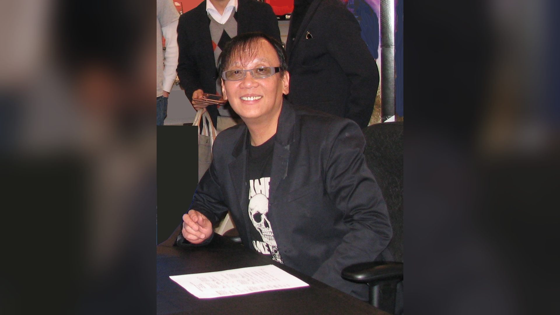 Yuji Horii AI game creation: the Dragon Quest creator smiling at a signing table